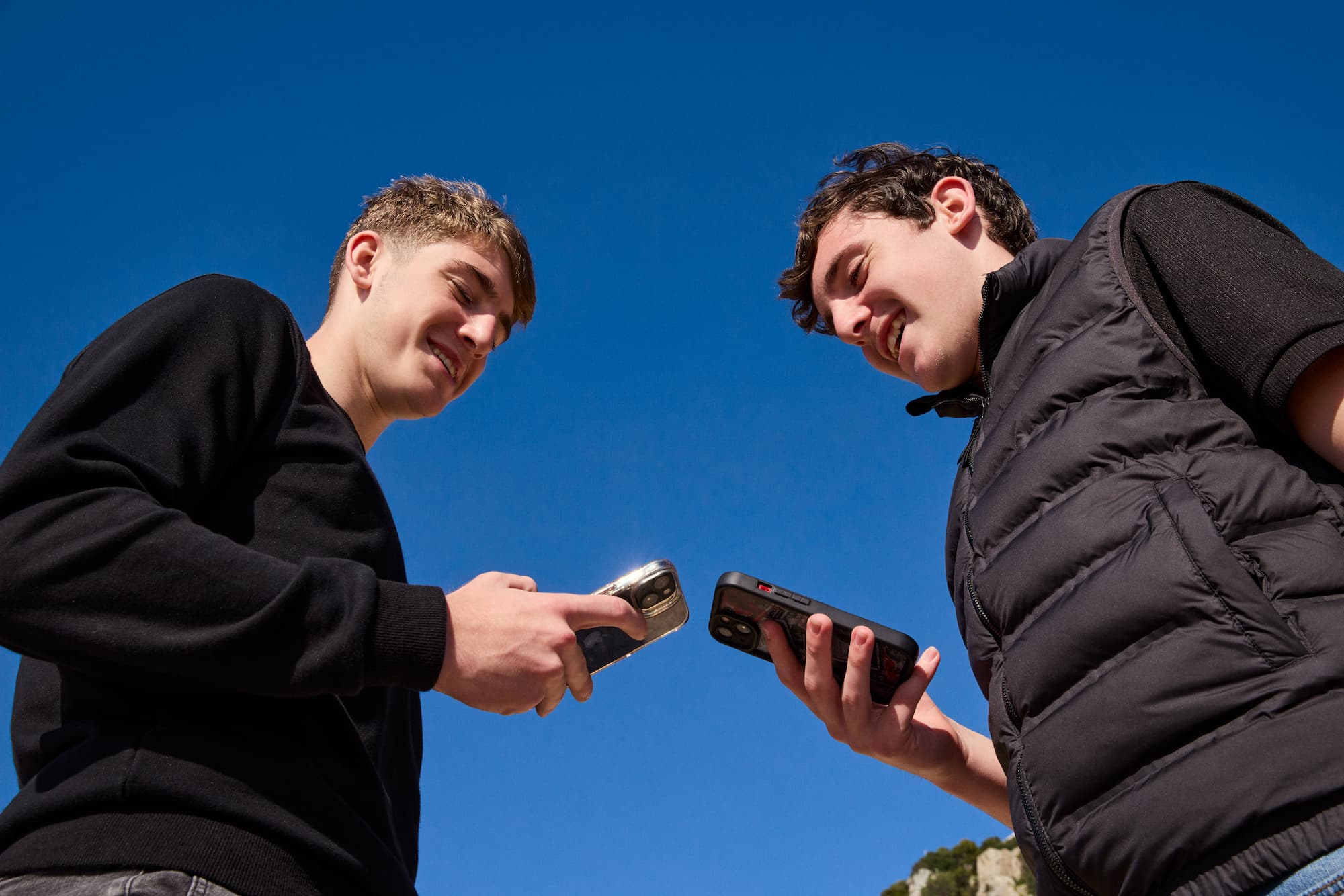two teens looking at their phones