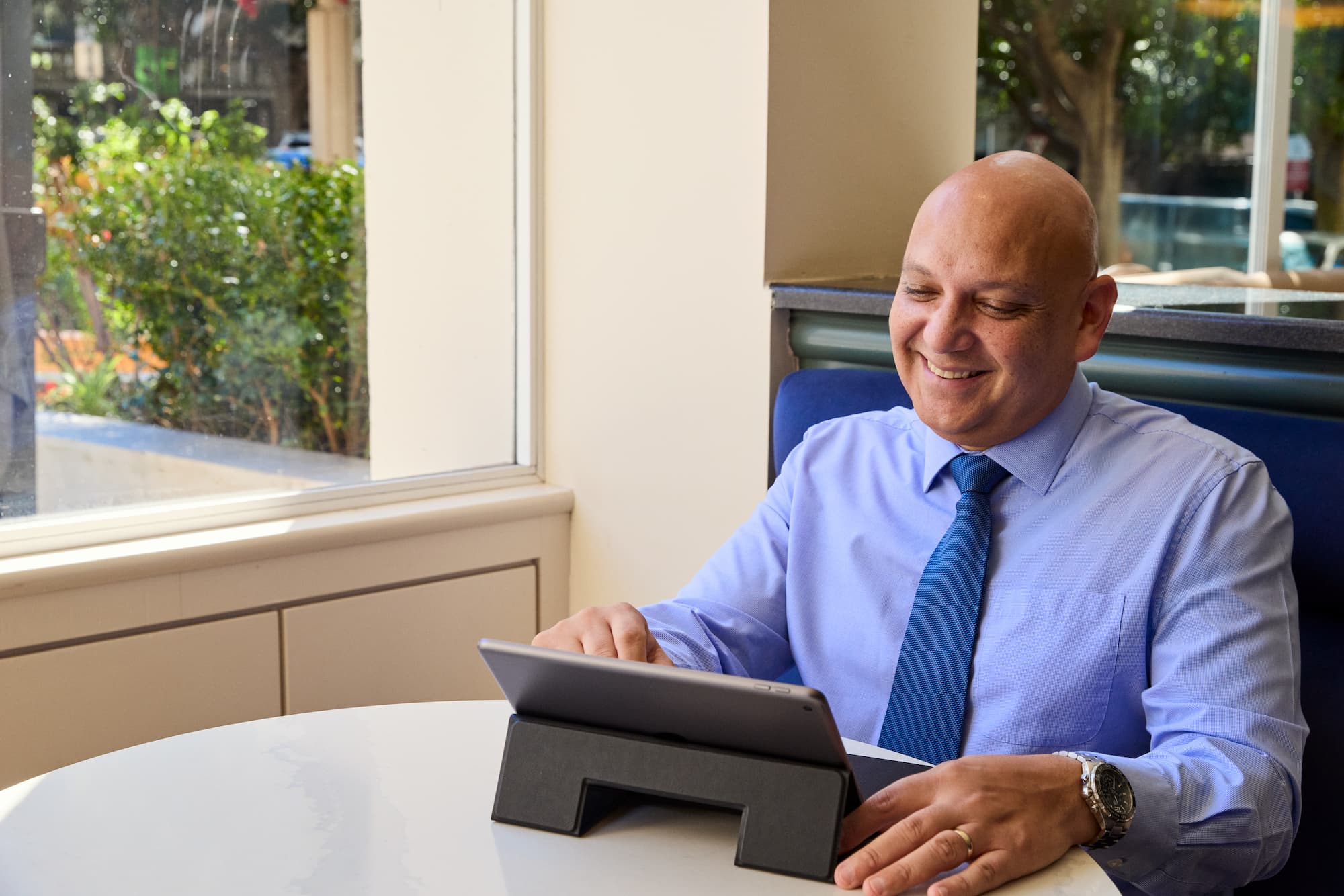 man sitting at the desk with a tablet