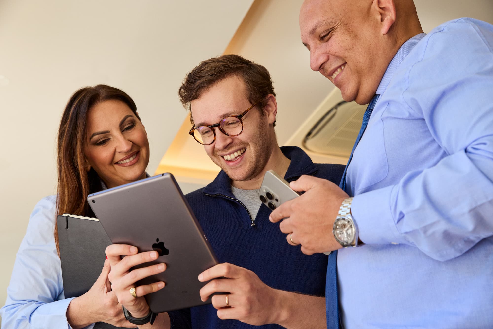 three people looking at the tablet