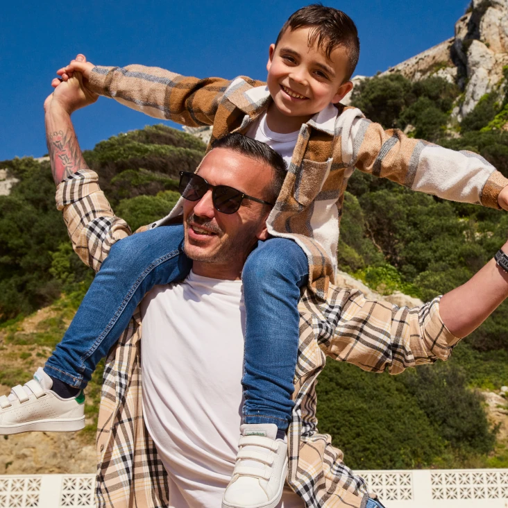 Little boy sat on fathers shoulders